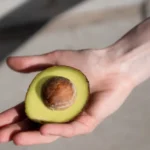 imagem de uma mão segurando um abacate / abacate para cabelo branco